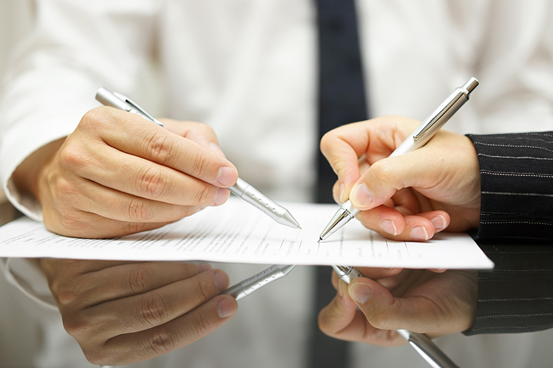 Business man is pointing woman where to sign document Business man is pointing woman where to sign document
